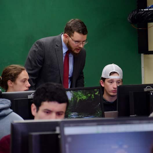 Dr. Charles Sprouse assisting students in Engineering class